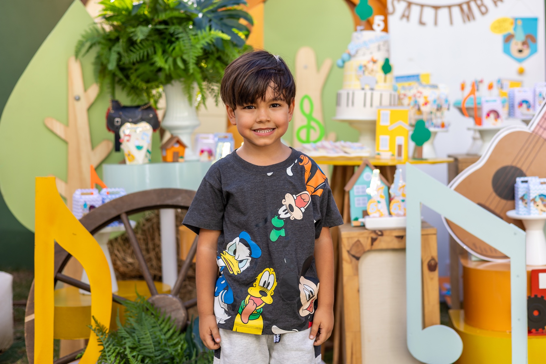 Menino diante da decoração de aniversário infantil