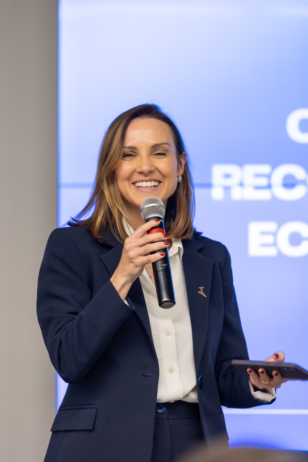 Palestrante com microfone em evento corporativo