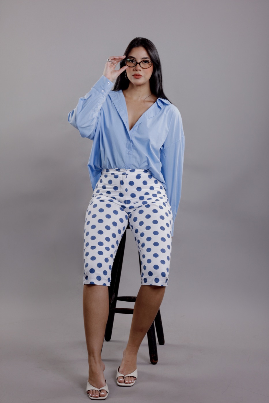 Retrato de mulher de óculos e camisa azul em estúdio